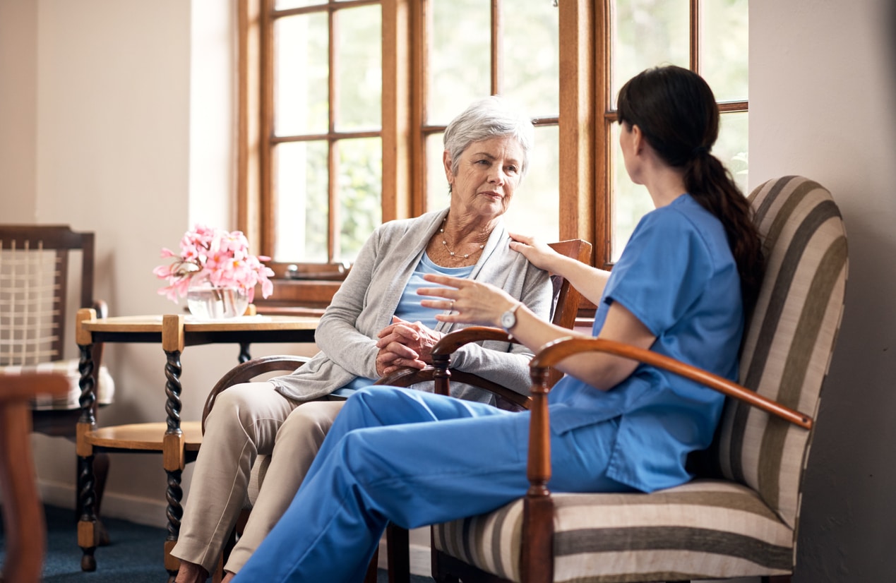 young nurse talking with an elderly woman in a retirement home