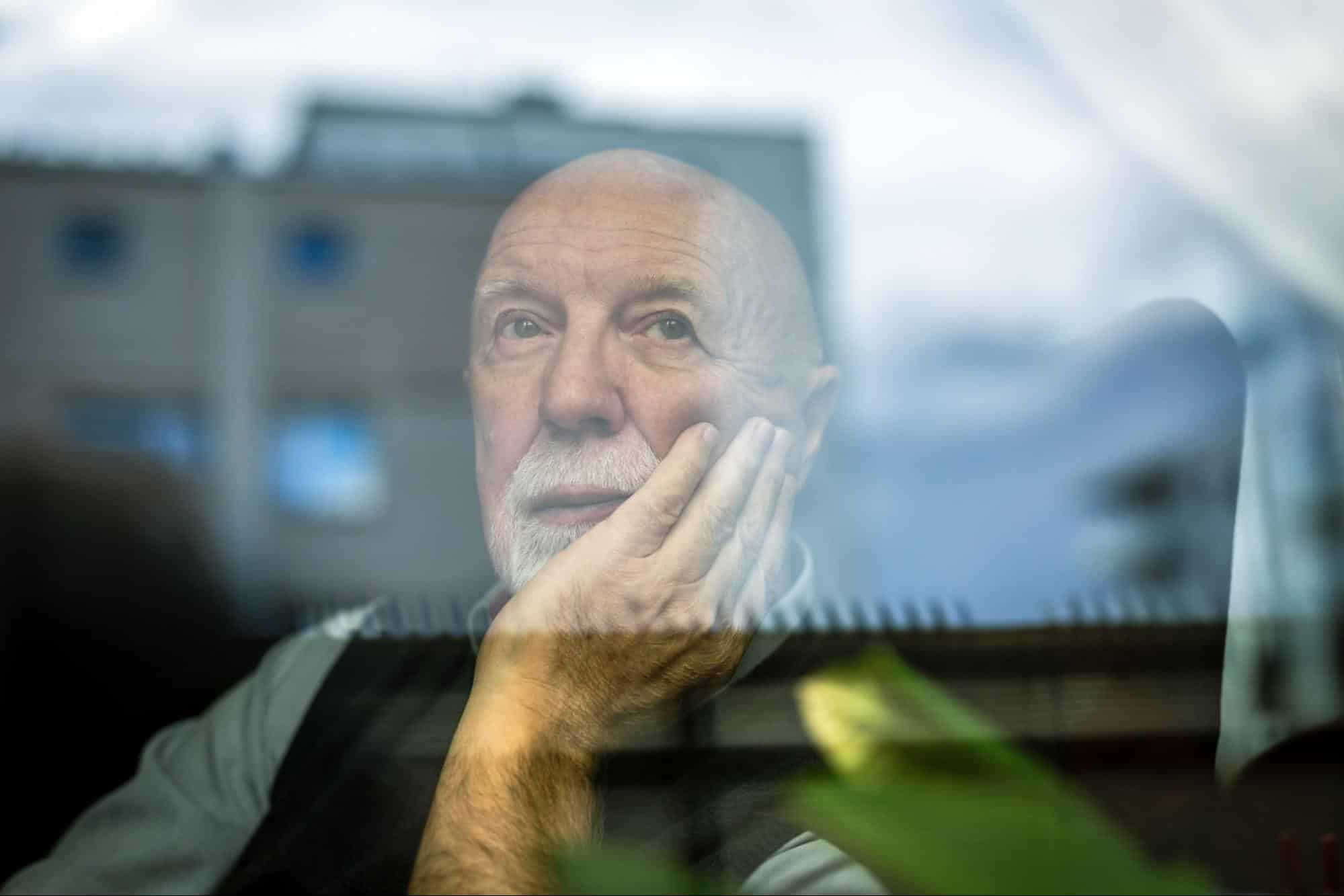 senior-looking-out-window-feeling-isolated